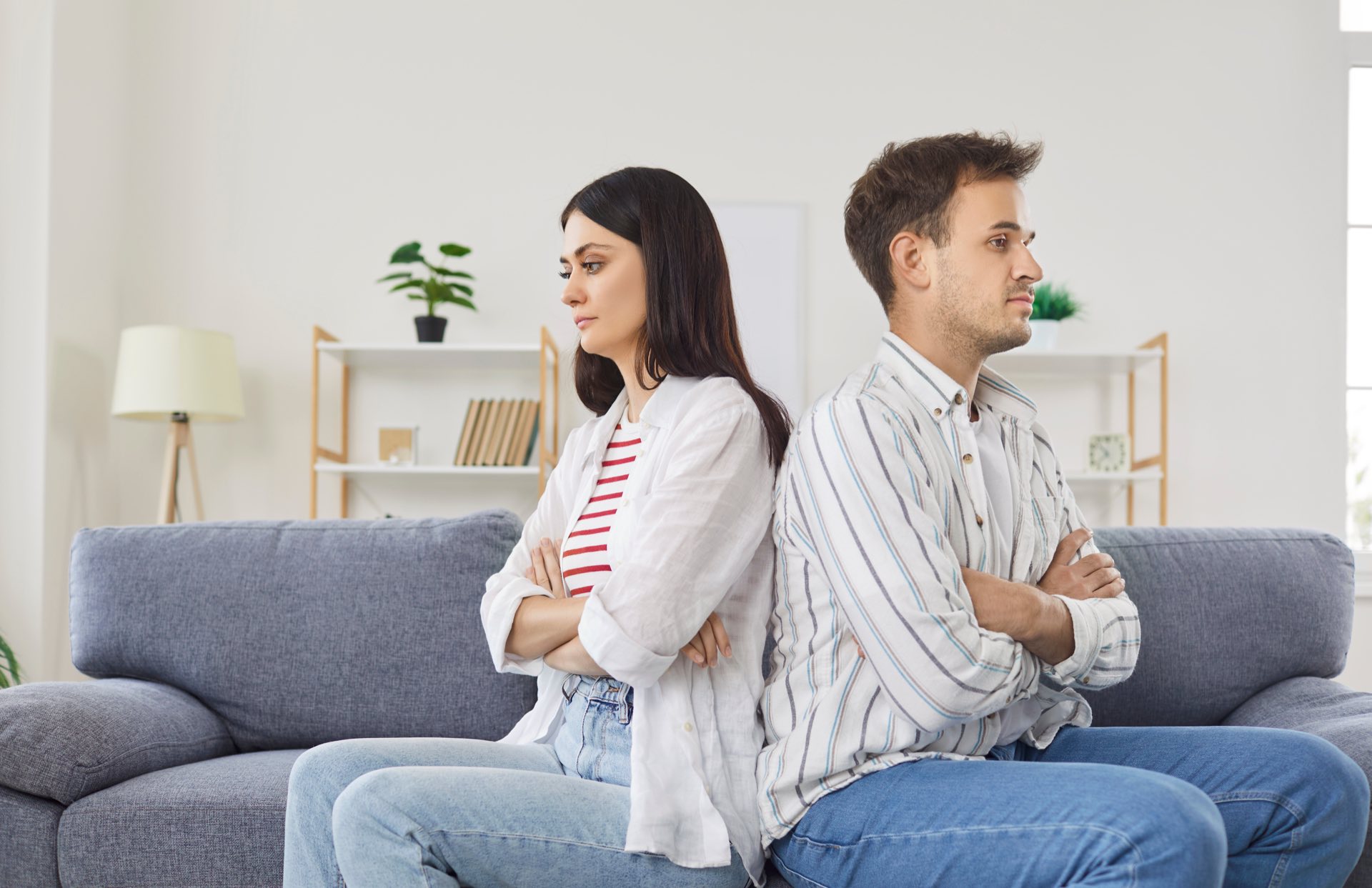 woman and man sitting back to back on blue couch