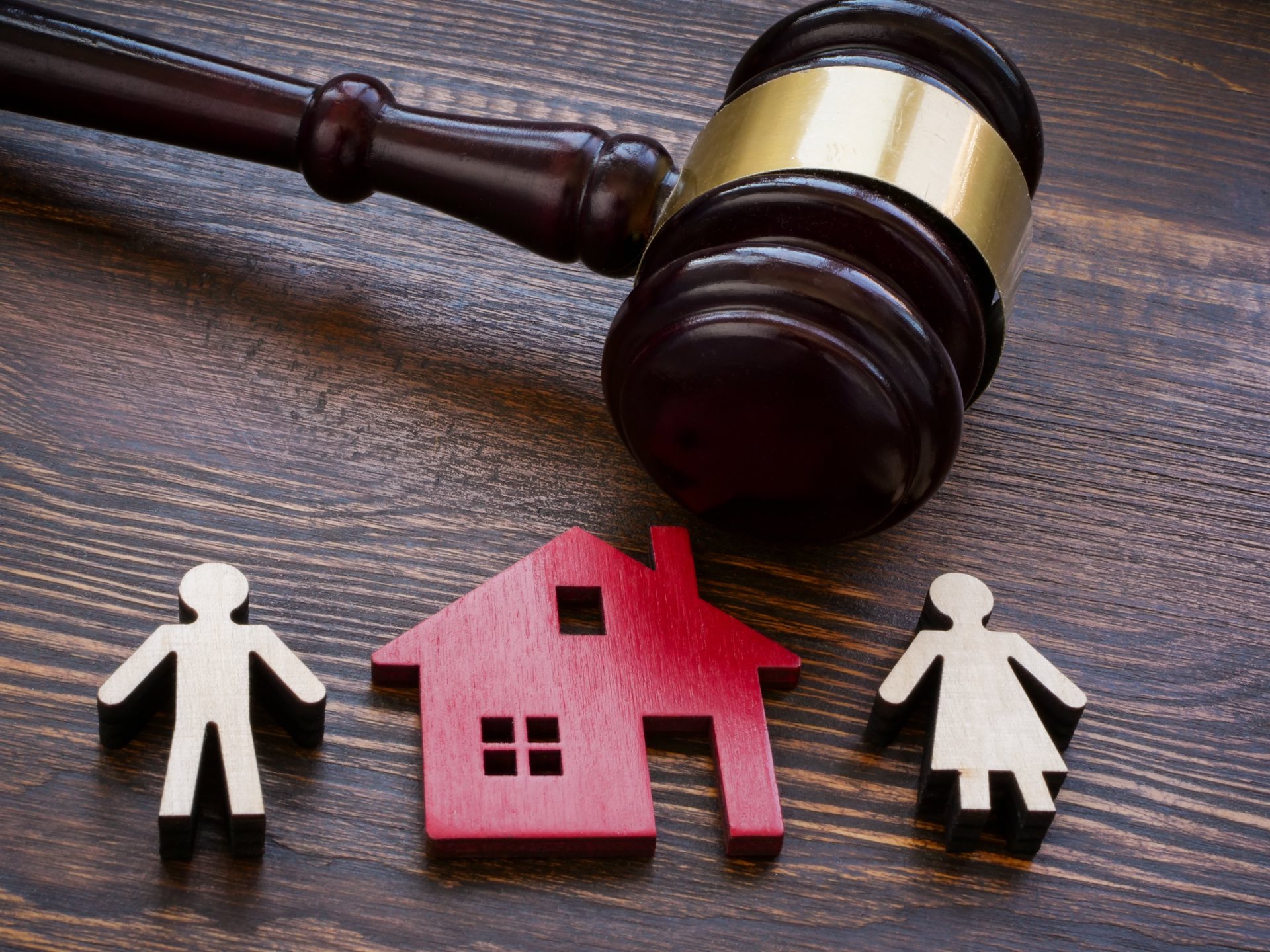 Gavel, figures of couple separated by a red wooden house