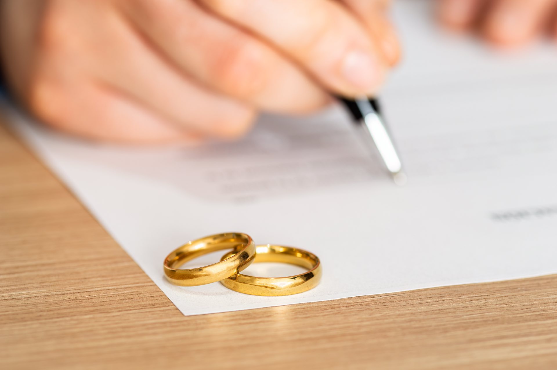 Rings on top of a piece of paper and hand holding a pen
